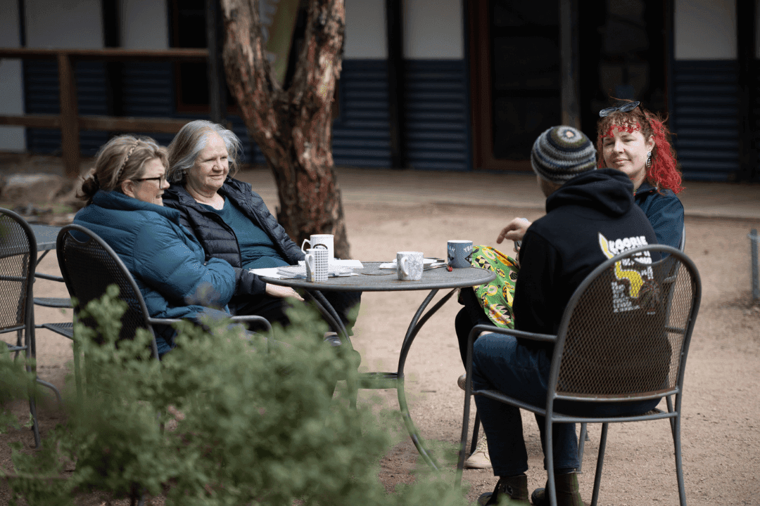 Participants in conversation at an outdoor table